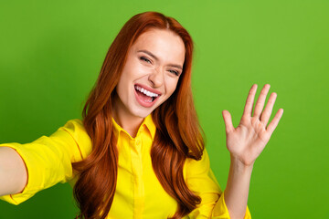 Canvas Print - Photo portrait of pretty young girl take selfie photo wave hand hello wear trendy yellow outfit isolated on green color background