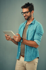 Wall Mural - Man, studio and reading with tablet and glasses, career with software programming in London. Male creative, ebook and gray background with happiness for digital job, mobile app or website development