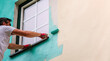 © E_Katsiaryna - A worker paints the facade walls of a house with paint using a paint roller