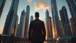 © EnricaDjango - Back view of a sharply dressed businessman standing against the impressive silhouette of towering skyscrapers.