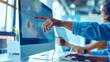© OMD - Close-up of a person's hand pointing at analytics charts on a computer screen in a modern office environment, indicating data analysis.