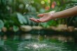 © mattegg - Nature Concept: Women's Hand with Close-Up Water Flow in Garden