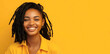 © Mladen - young smiling black woman dreadlocks jumpsuit skin care beauty skincare cosmetics yellow background copy space