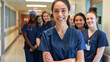 © Maksym - Nursing student in scrubs, smiling and standing with her diverse team in a bright hospital corridor, showcasing teamwork and unity