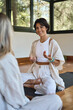 © insta_photos - Young happy Hispanic woman yoga coach training group class yoga meditation session sitting in yoga pose in studio talking to community teaching people during retreat mind body health therapy. Vertical