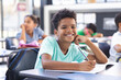 © Wavebreak Media - In school, young biracial boy with curly hair is writing in the classroom
