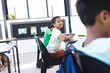 © Wavebreak Media - Biracial boy smiles, looks back at classmate in school classroom