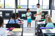 © Wavebreak Media - In school, young Asian male teacher is talking to a biracial male student