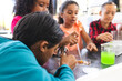 © Wavebreak Media - Biracial children do a school science experiment, one using a magnifying glass