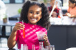 © Wavebreak Media - Biracial girl with curly hair smiles while holding a pipette and cup in a science class at school