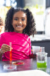 © Wavebreak Media - A biracial girl with curly hair is conducting a science experiment in school