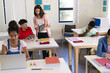 © Wavebreak Media - Young biracial female teacher instructs in a high school classroom, with copy space