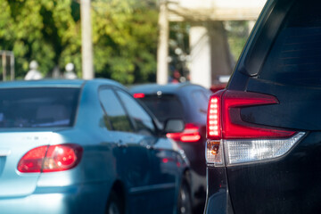 Wall Mural - Rear side of cars on traffic jam on the roads. With turn on brake light. During time in rush hours for travel or business work in the city. with effect orange light for background.