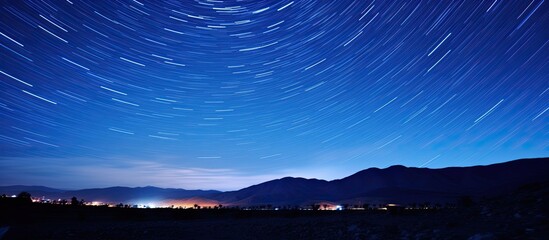 Wall Mural - Night sky with stars above a farm with mountains surrounding it and a clear copy space image.