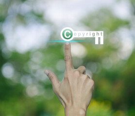 Sticker - Hand pressing copyright key icon over blur green tree in park, Copyright and patents concept