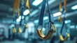 © anza - A suspension trainer's handles hanging from a gym ceiling, focus on the texture and material, with a softly blurred background of gym equipment.