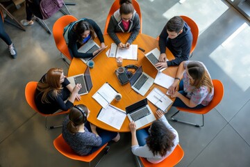 Poster - Collaboration in modern workspace involves a team meeting around a round table with laptops and notes. It is a setting for teamwork, discussion, and brainstorming among professionals using technology