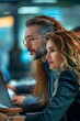 © Molang Visual - Two business people looking at a laptop screen
