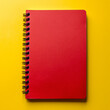 © Nasreen - A red notebook placed in the top right corner of a solid yellow background, ready for taking notes.