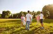 © Studio Romantic - Happy joyful children boys and girls playing with a ball on a green grass in the park outdoors. Kids standing in a circle on the lawn in the garden catching ball and having fun in summer camp.