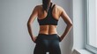 © Archibalttttt - Back view of a fit young woman wearing tight black fitness leggings and a sports bra