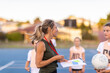 © Austockphoto - blonde female netball coach with school kids on netball court