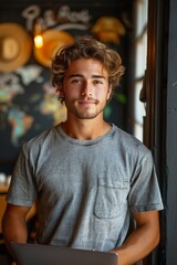 Wall Mural - A stylish young waiter takes orders with confidence, standing at a laptop in a modern cafe.