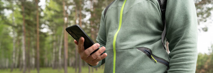 Wall Mural - Person using mobile phone in forest 