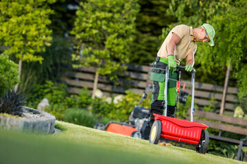 Wall Mural - Man Spreading Fertilizer on Green Lawn