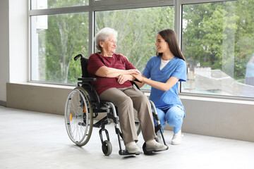 Canvas Print - Senior woman in wheelchair with nurse indoors