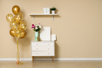 Sticker - Beautiful golden air balloons with home decor and flowers on commode near beige wall at home