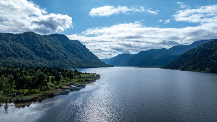 Wall Mural - beautiful landscape with mountains and Lake Teletskoye against a background of blue sky from a drone in May