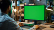 © MariКа - Indian office employee is working at a desktop computer with a mockup green screen. advertising work as a programmer, web developer, tester, Data Scientist
