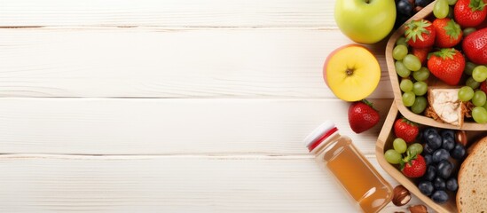 Wall Mural - Top view of a nutritious lunchbox including a sandwich, fresh vegetables, water bottle, and fruits on a wooden backdrop with copy space image.