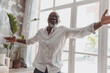 © Martinesku - Positive elderly black man dancing in his house. Symbolizing joy and happiness, a wellbeing concept