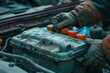 © Skip Monday - Auto repair service technician working on electric battery - High details, 8K UHD. Mechanic's hands checking and maintaining the car's electrical system.