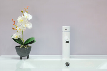 Poster - A white sink with a flower in a vase on top of it
