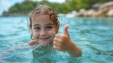It's summertime and a cute little girl is swimming in the sea during the weekend. This is a concept of a happy kid on vacation.