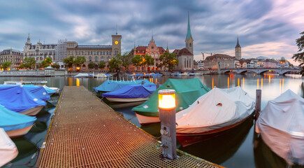 Wall Mural - Panoramic view of Zurich dock on Limmat River with boats and Fraumunster at dusk, Switzerland
