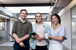 © Austockphoto - Three businesspeople smiling at the camera in an office