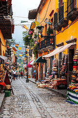 Vibrant street market in a charming old town with colorful buildings and cobblestone streets filled with local vendors selling handmade crafts and traditional goods perfect for travelers

