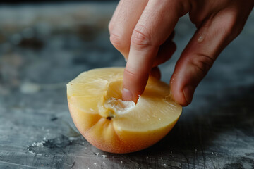 Wall Mural - finger in fresh peach halve on dark surface