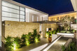 © alhim - Modern Mediterranean Courtyard With Stone Walls and Nighttime Lighting. Magnificent night view of the illuminated villa with landscaping.