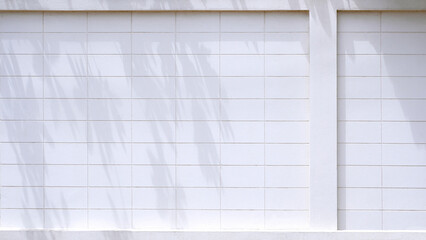 Wall Mural - White prefabricated concrete block fence wall with rectangle pattern in front of building with sunlight and branches shadow on surface 