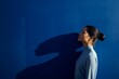 © alisaaa - thoughtful woman standing against blue wall
