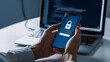 © Emqan - A person's hands holding a smartphone, with an emphasis on the screen displaying a padlock
