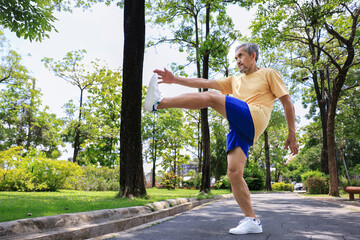 Senior Asian man is stretching his leg muscle during warm up exercise work out in the morning at public park for healthy and longevity