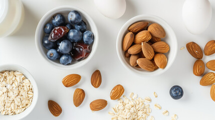 A white table with dates, blueberries, almonds, oats, cashews and eggs，food