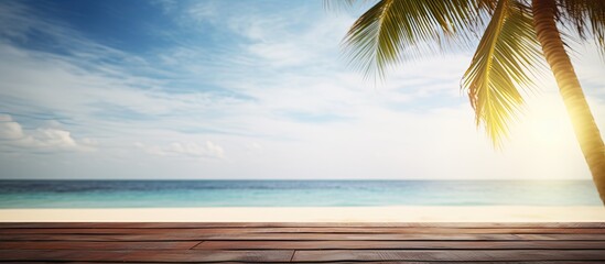 Sticker - Tropical fine sandy beach with blured sea sun sky clouds background with wooden table top and empty space for product advertisement Montage of summer relaxation background. Creative banner