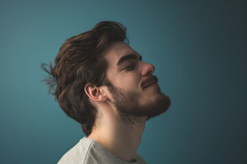 A close up of a man with beard and closed eyes looking to a side